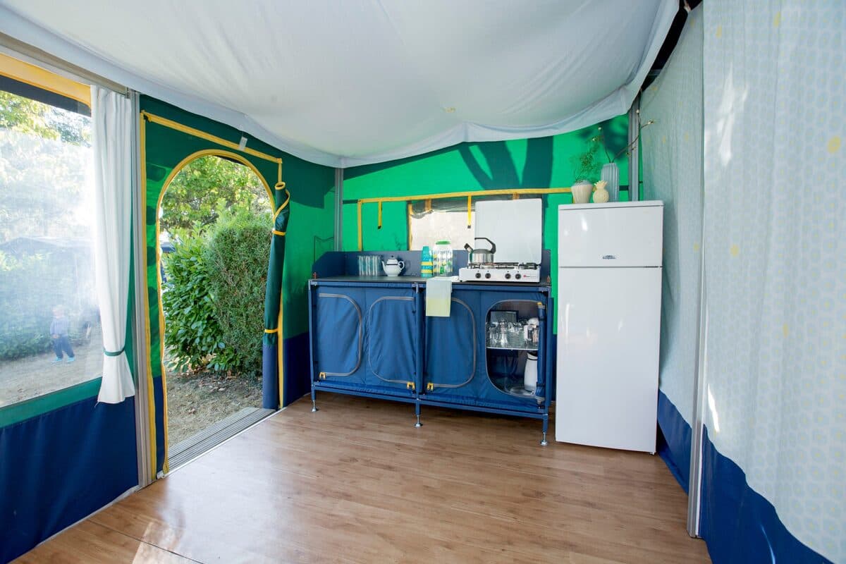 Keukenblok en frigo, met de deur open naar de camping
