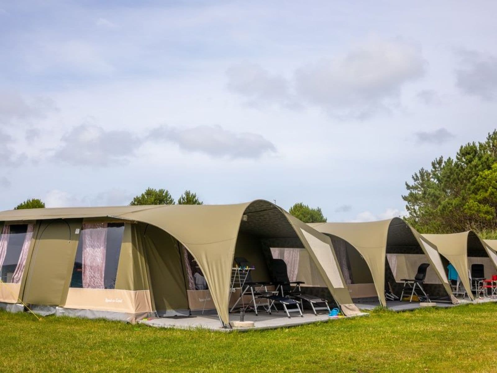 Een rij bungalowtenten met overdekte terrassen